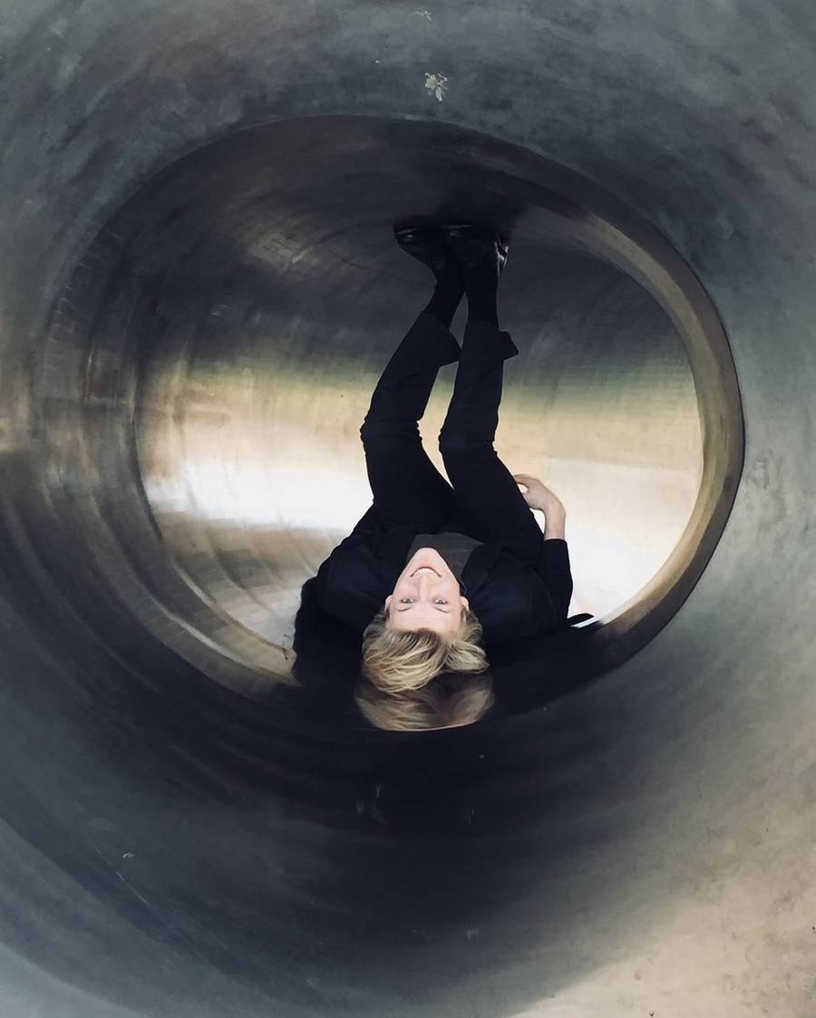 Lying inside a concrete tunnel, feet up